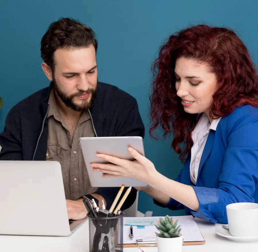 Two people reviewing notes on a laptop